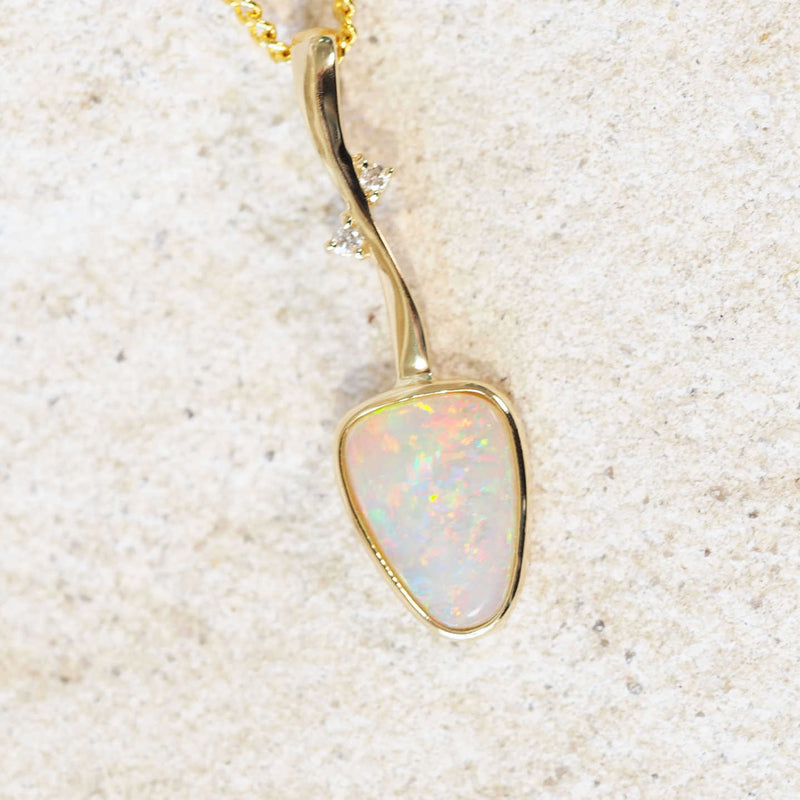 colourful triangular crystal opal set into a gold pendant 