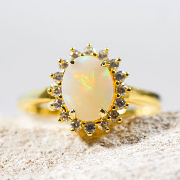 colourful oval white opal set in a gold plated silver princess design ring surrounded by 16 crystals