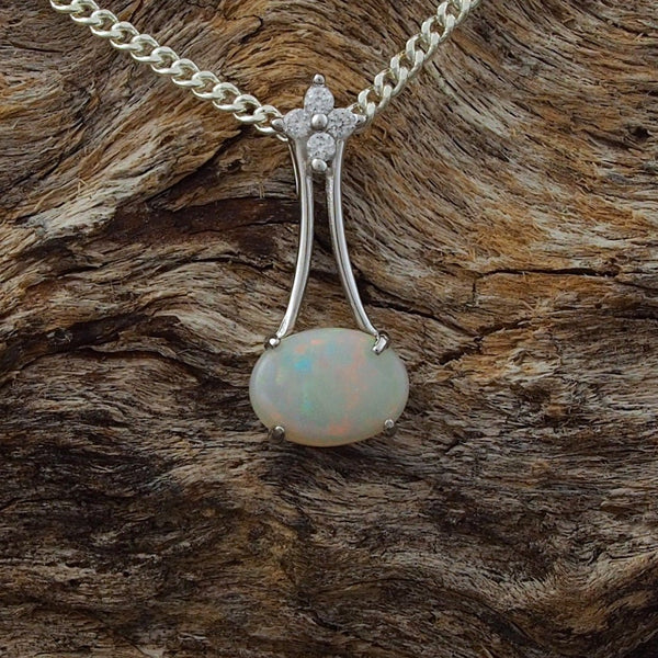 Elegant necklace pendant claw set with a colourful oval shape white opal and four cubic zirconias.